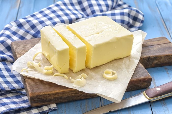 A stick of butter with chunks cut out of it.